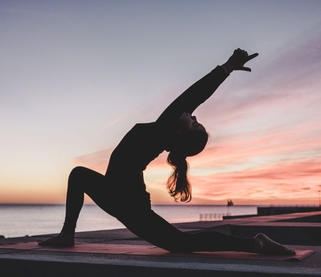 Individual doing yoga during sunset